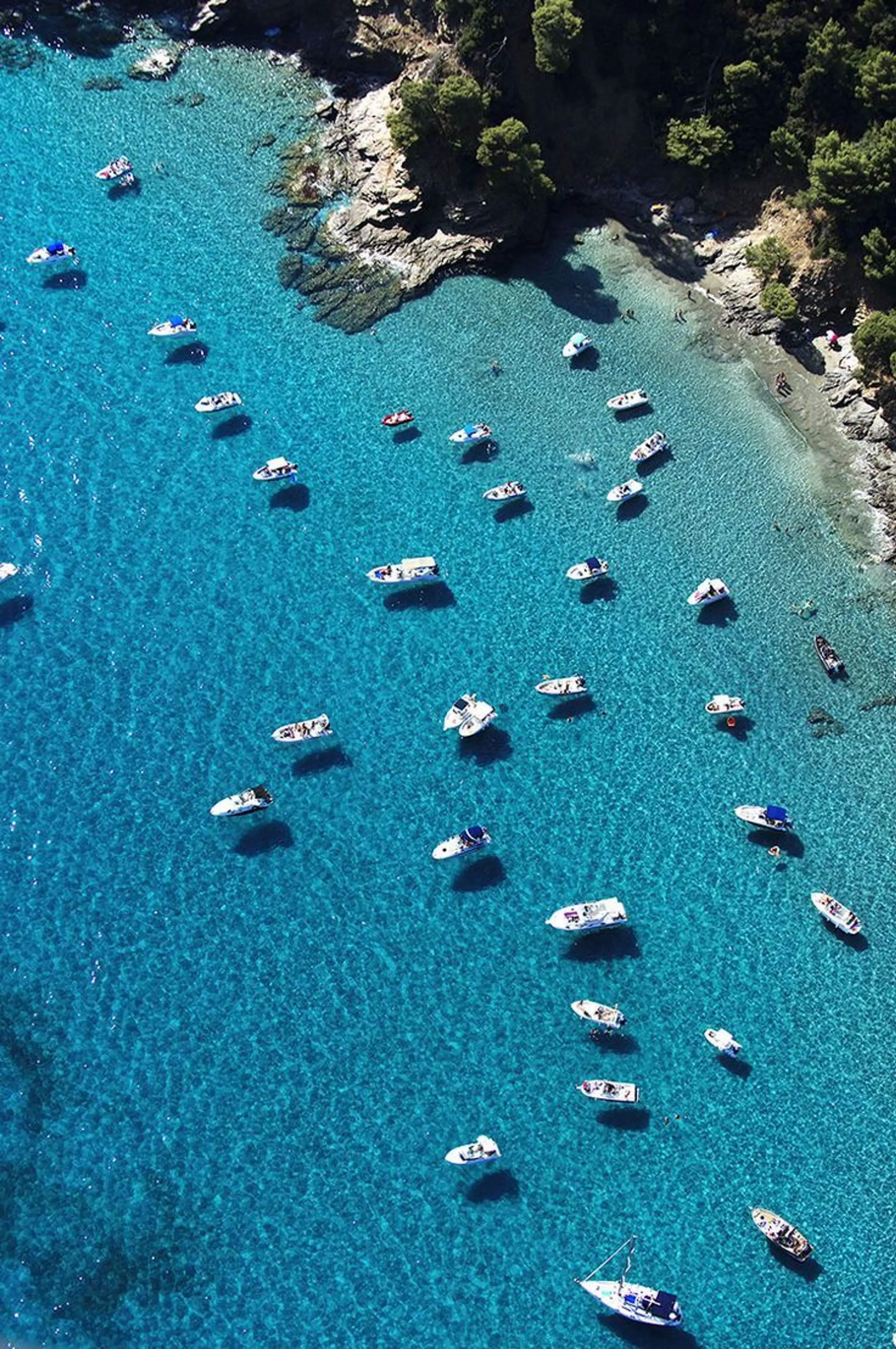 Boats anchored in clear turquoise water along Pampelonne 