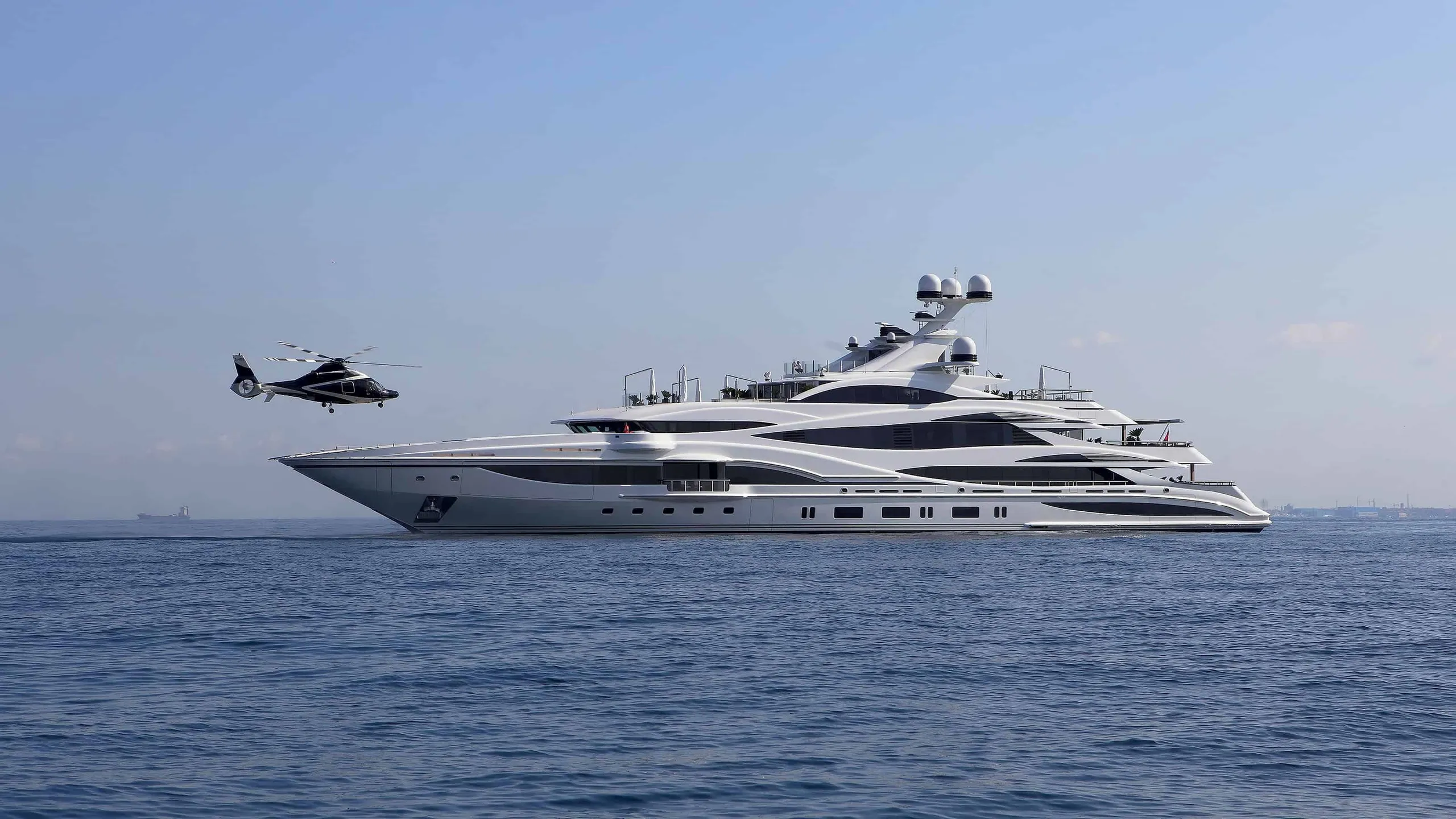 Large superyacht with helicopter cruising at sea
