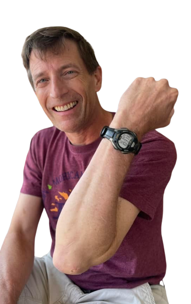 David Corfman, the race director, grinning with one arm raised to show his watch.