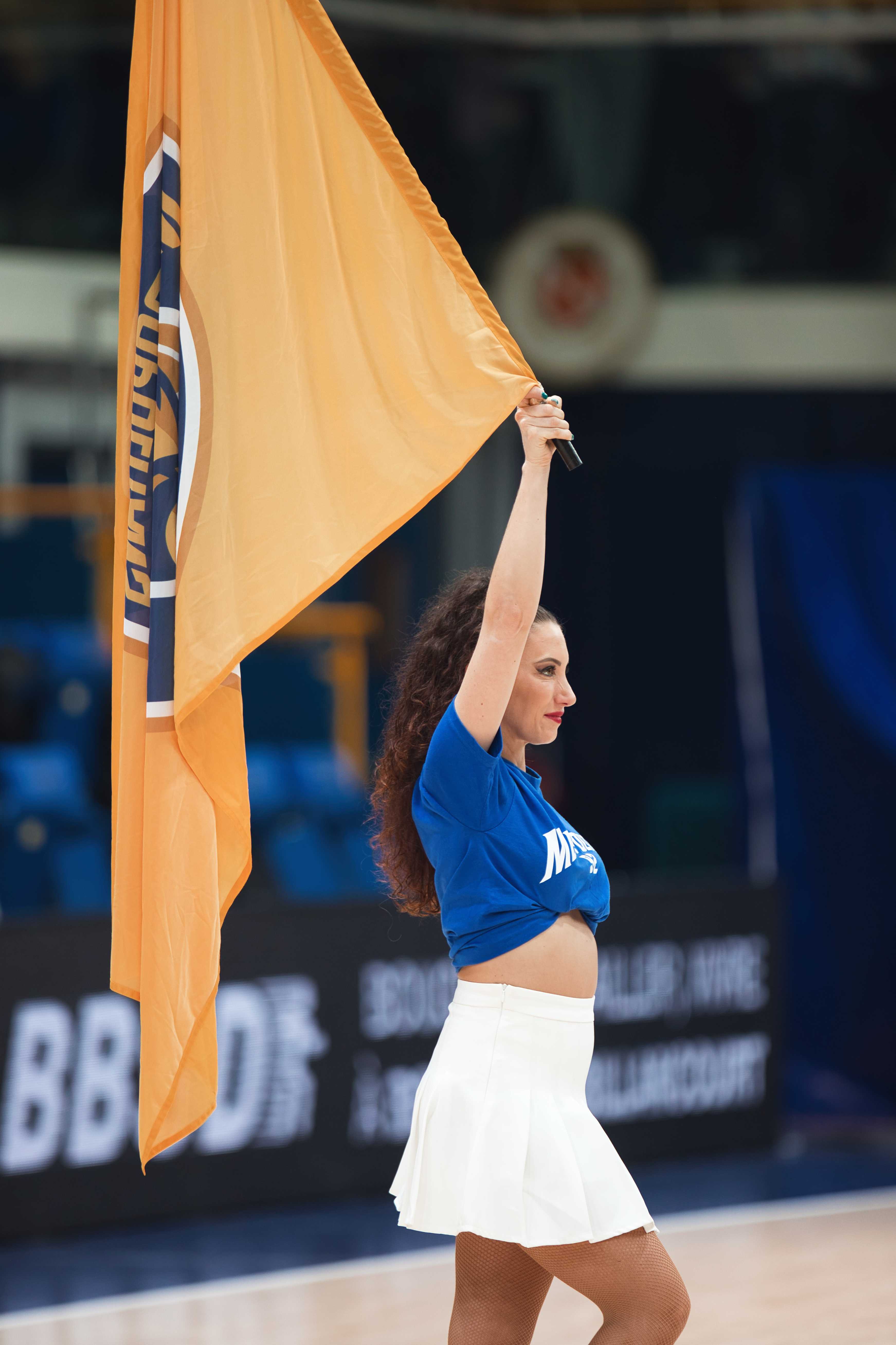 Danseuse brandissant un grand drapeau orange aux couleurs du club