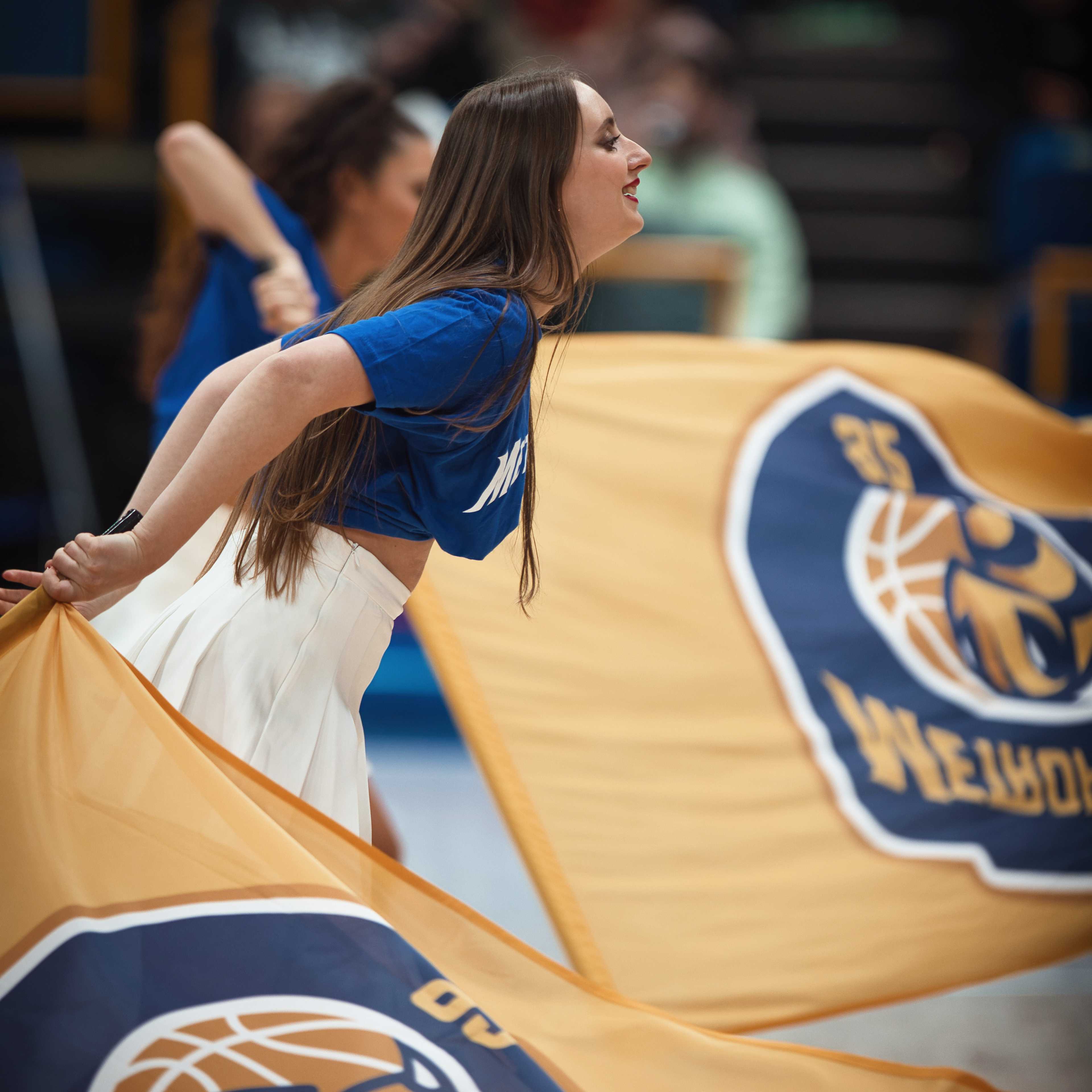 Danseuse faisant tournoyer deux grands drapeaux de club