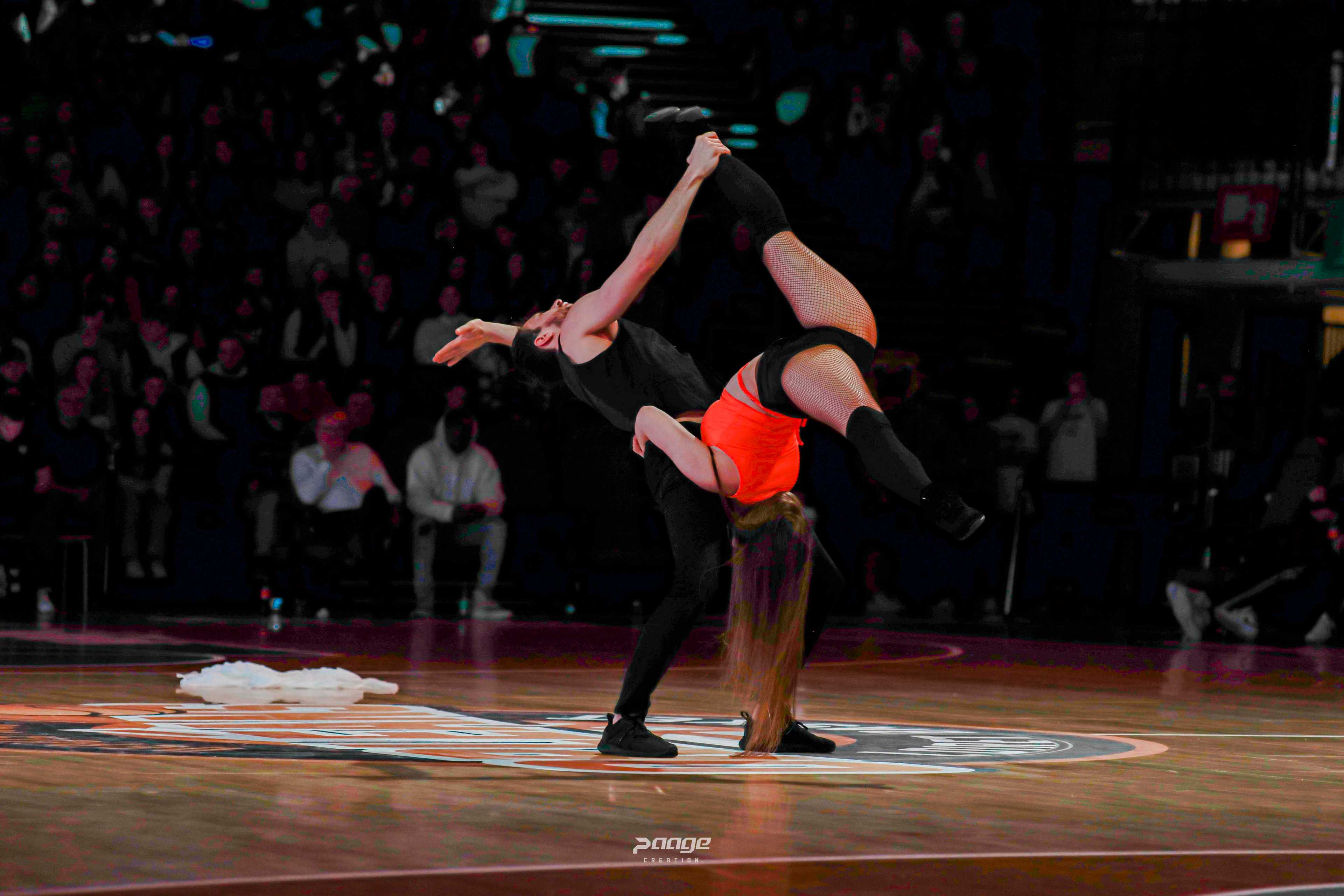 Porté acrobatique tête en bas au centre d'un parquet de basket