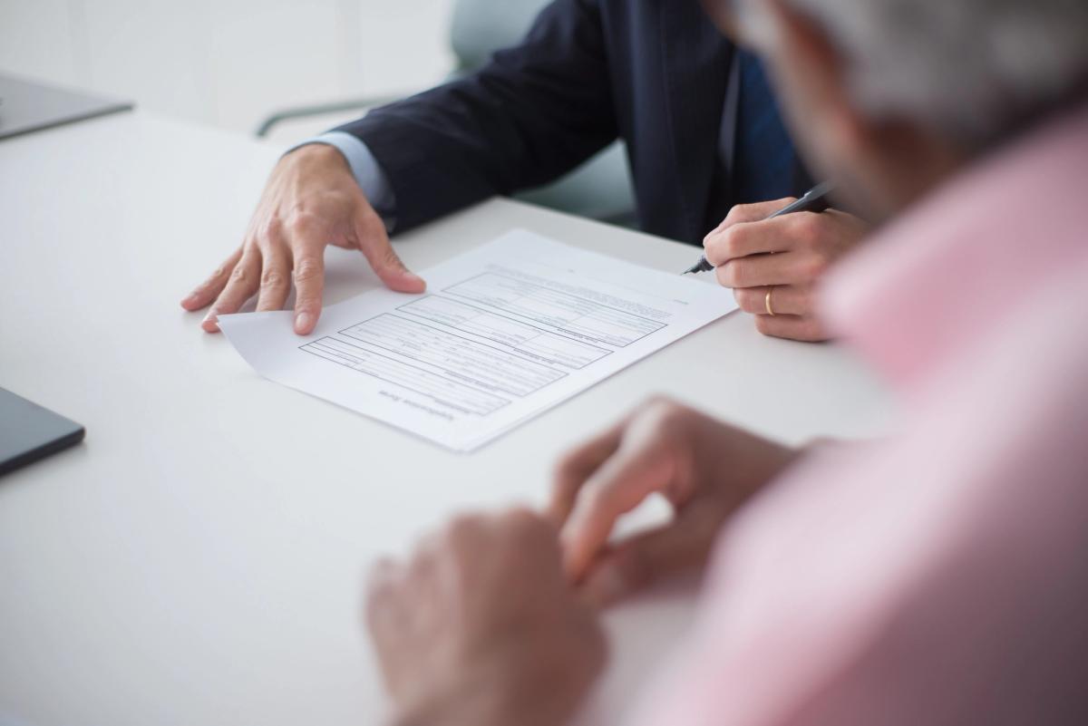Integrador solar e cliente assinando contrato de financiamento durante reunião comercial