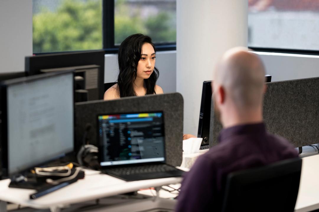 Two digital marketing experts working at desks in a CRO agency.