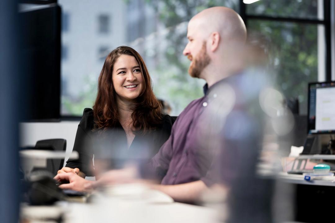 Female digital marketing consultant smiling at collegue.