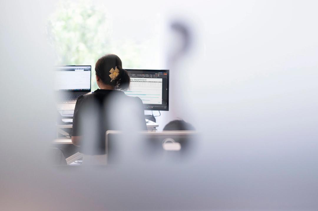 Blurred view of female search engine optimisation expert working at a desk.