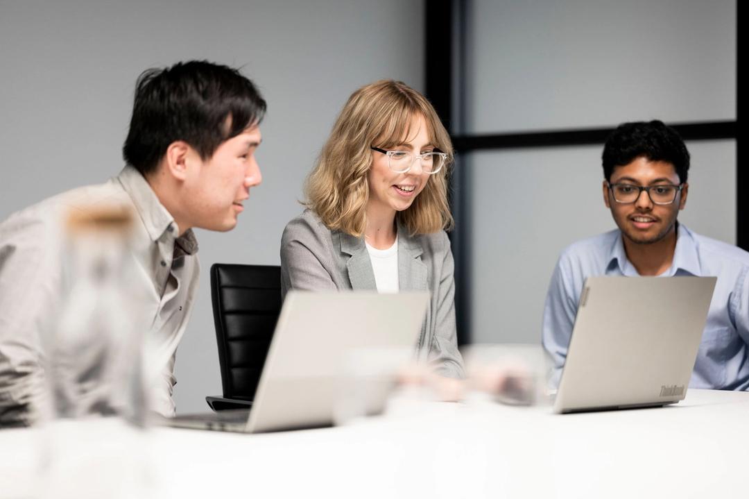 Three website designers discussing project in an office.