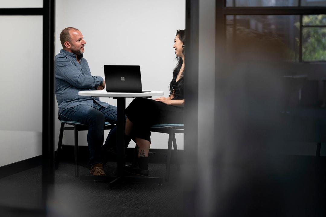 Male digital marketing consultant speaking in meeting room with client.
