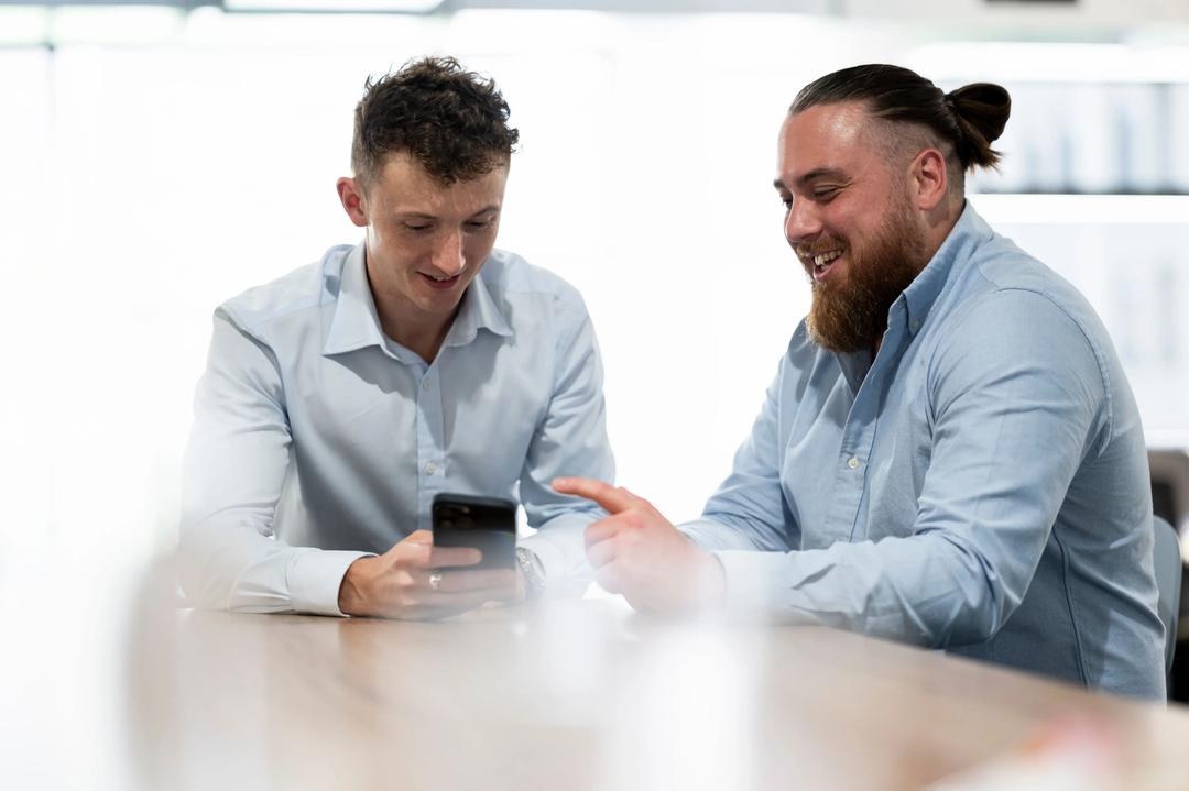 Two digital marketing experts looking at phone at a Paid Social Media Agency