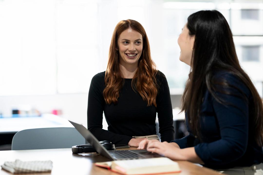 Two female SEO copywriters discussing a project.