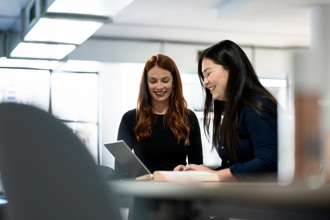 Two female Bing Ads experts strategising in office.