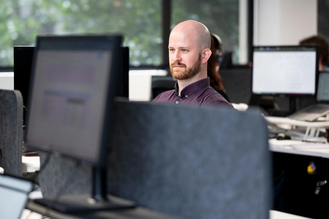 Male employee working at desk at a web analytics agency.