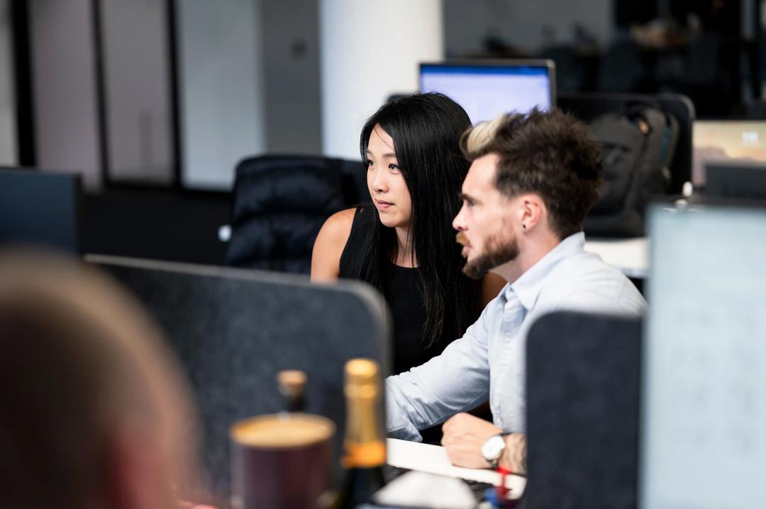 Male and female local SEO experts working at office desk on a strategy.