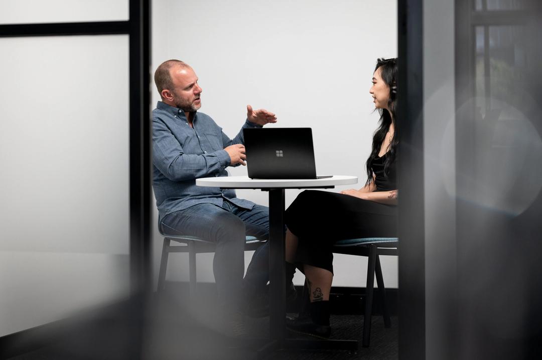 Male performance marketing expert explaining findings to client in meeting room.