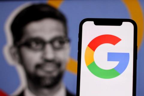 Google logo is displayed on smartphone screen with CEO Sundar Pichai in the background.