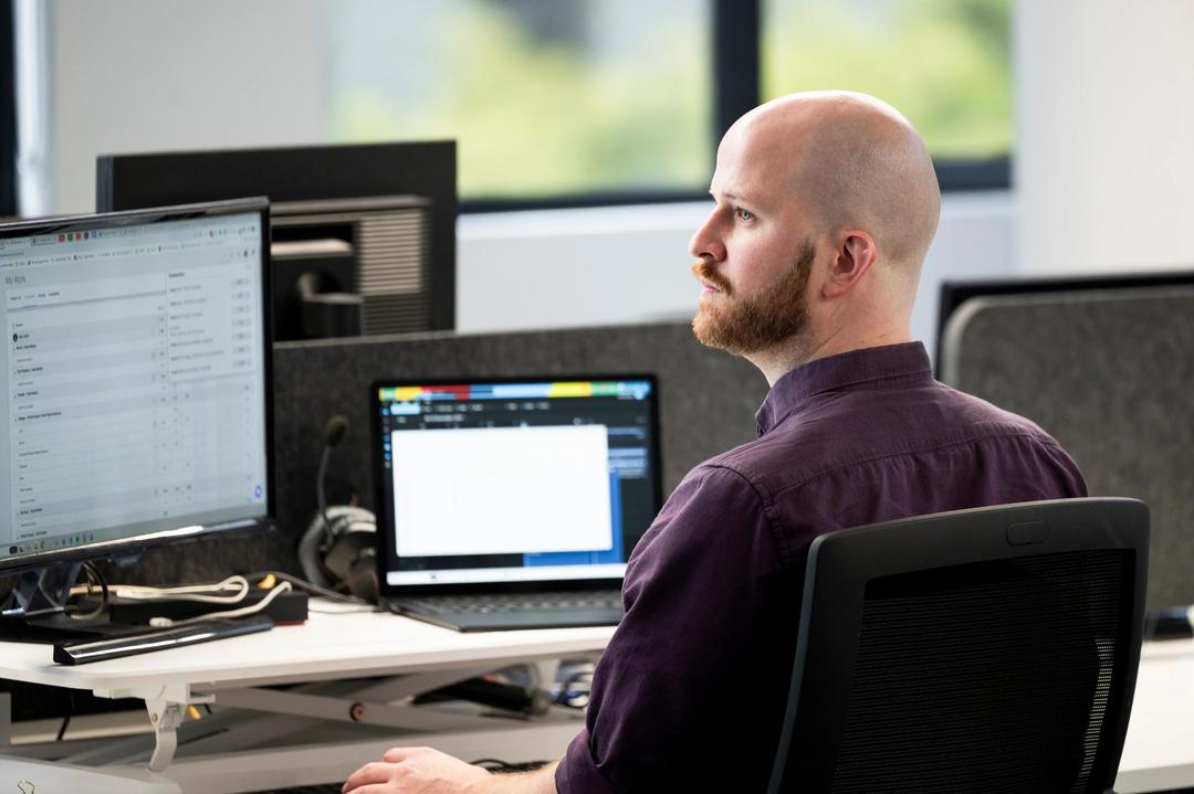 Male GA4 expert working at computer in office.