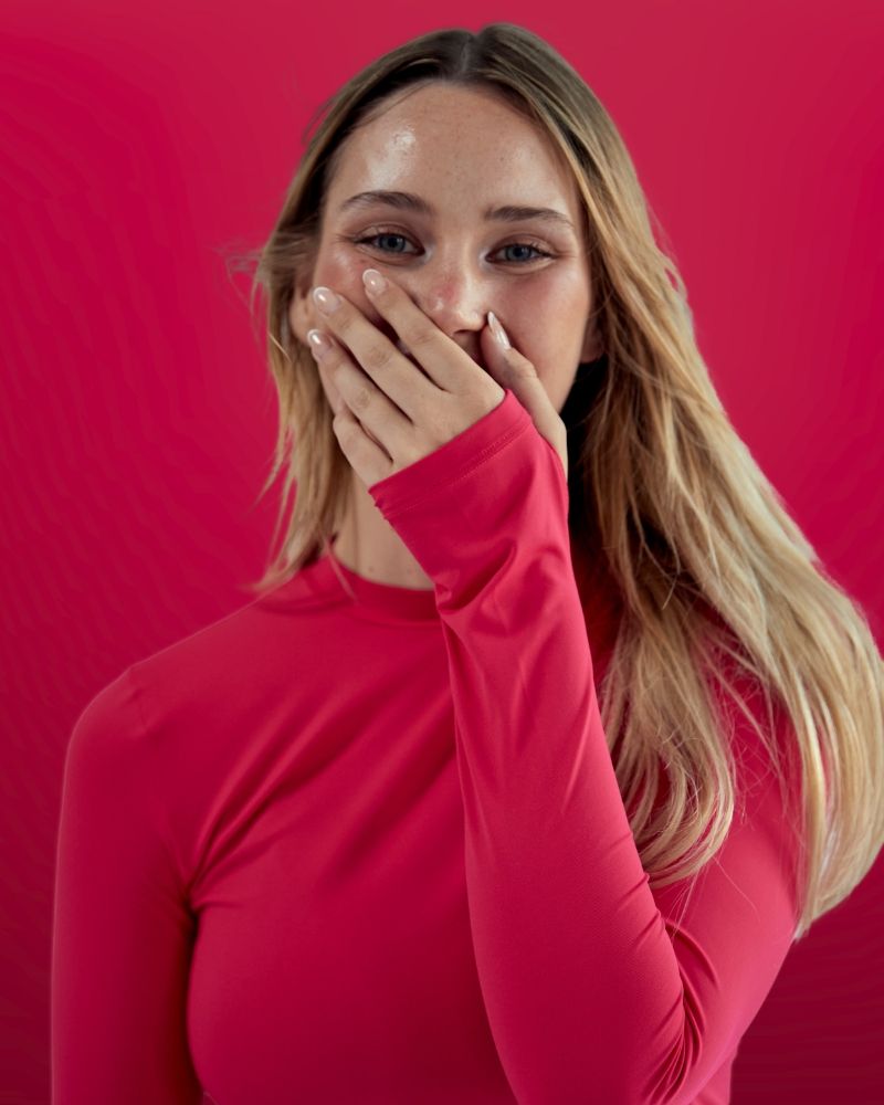 Frau lacht im pinken SPORTKIND High Neck Tennis Longsleeve