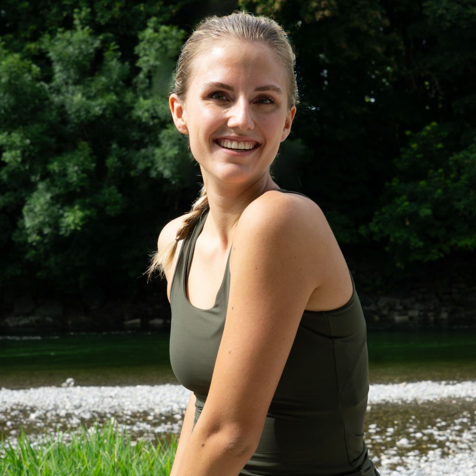 Frau im khaki grünen SPORTKIND Sportoutfit strahlt 