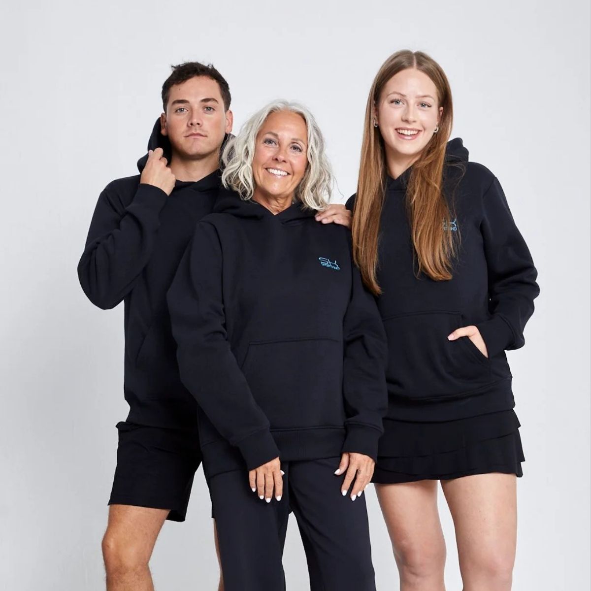 Zwei Frauen und ein Mann mit schwarzen Sportkind Outfits