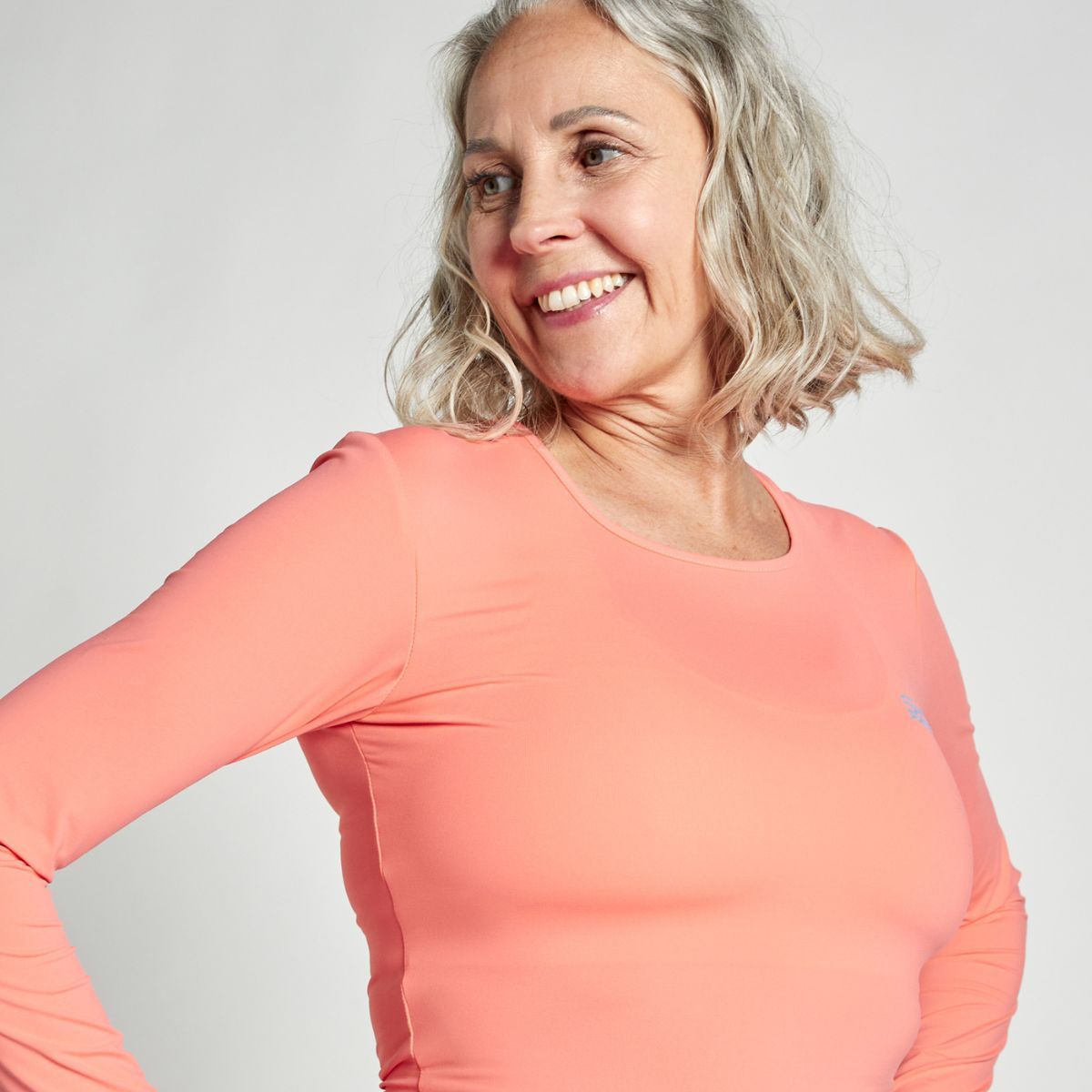Woman in an apricot-colored SPORTKIND long sleeve