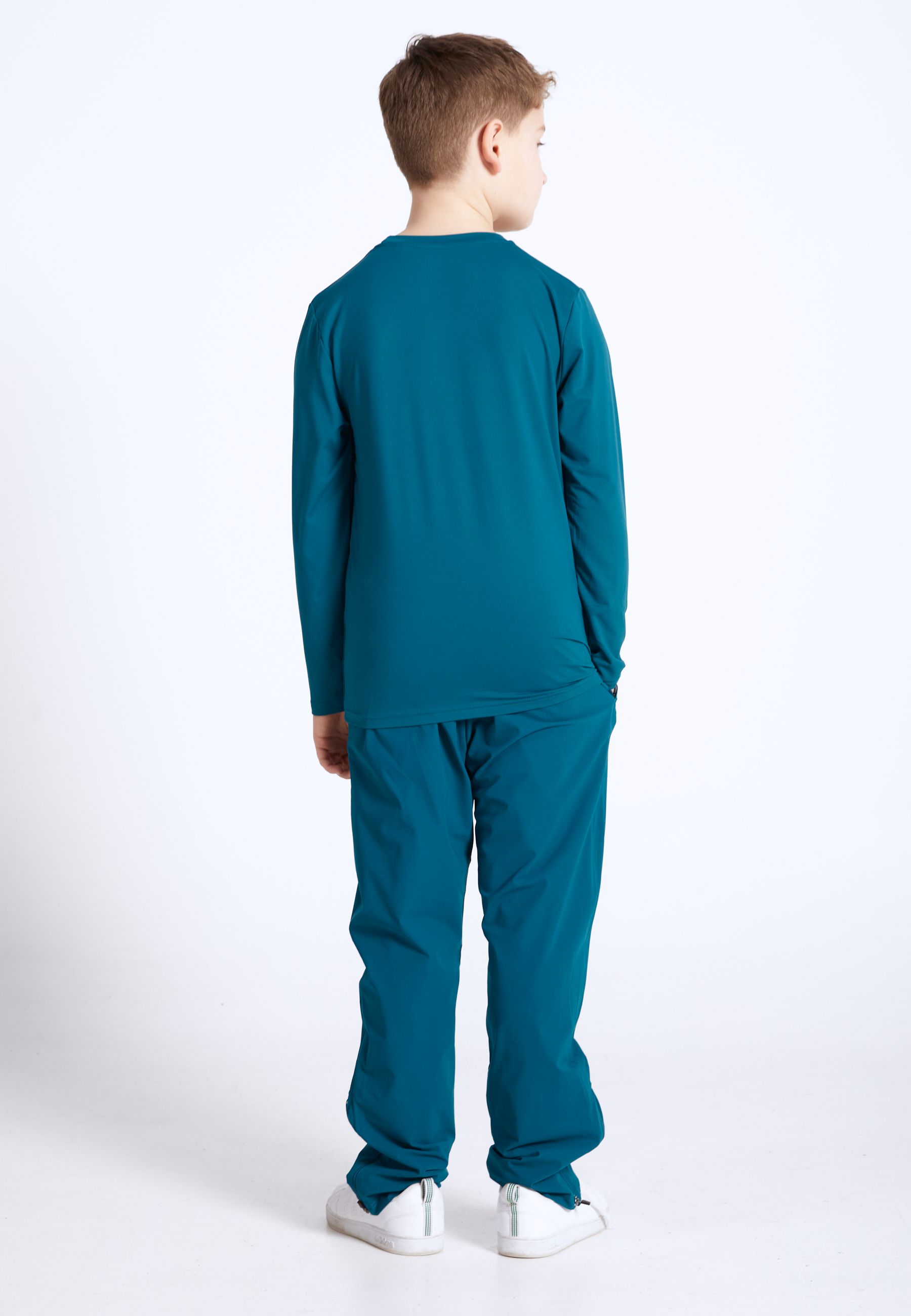 Boy in a petrol green Sportkind tennis outfit