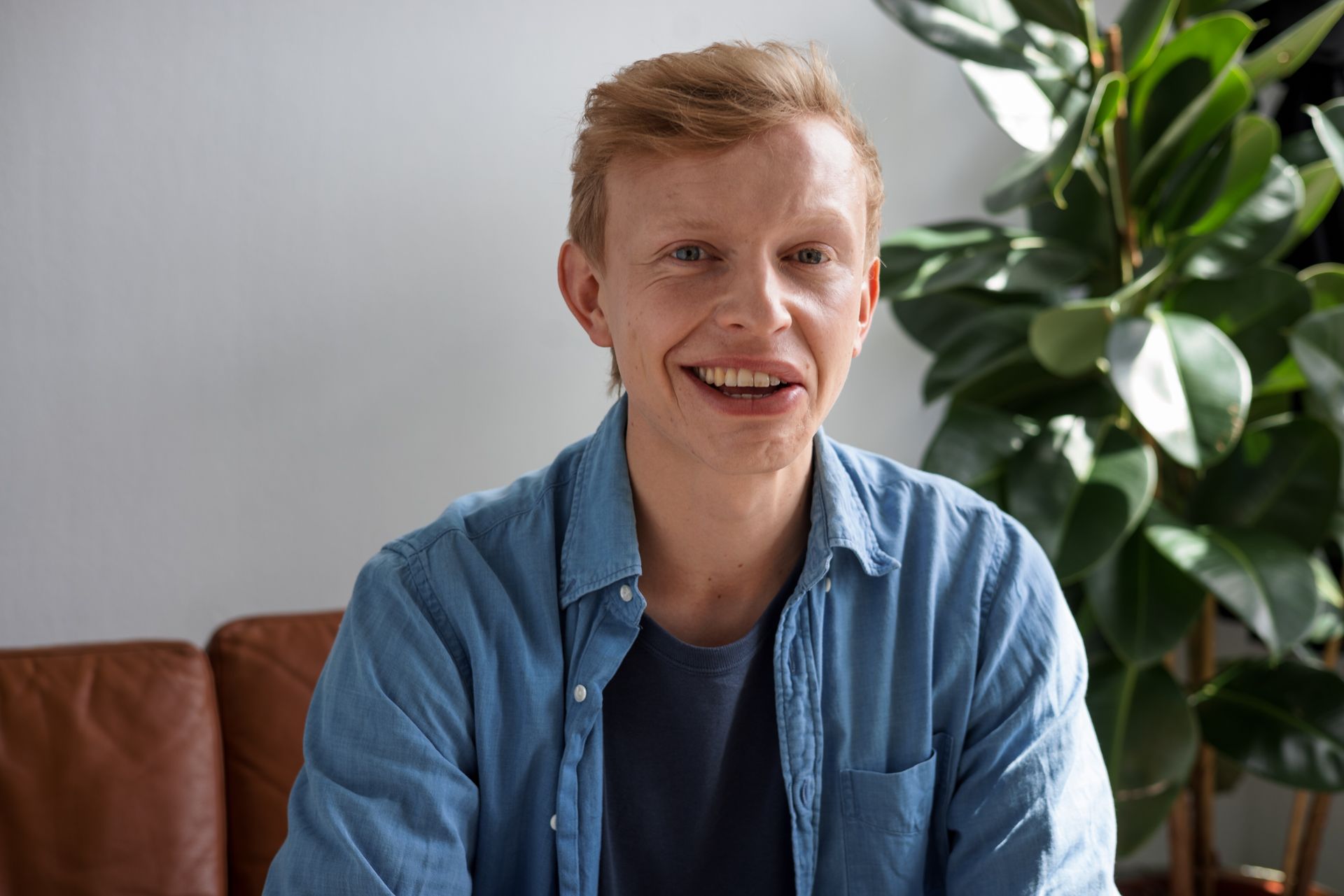 Junger Mann mit Synkinesien lächelt charmant