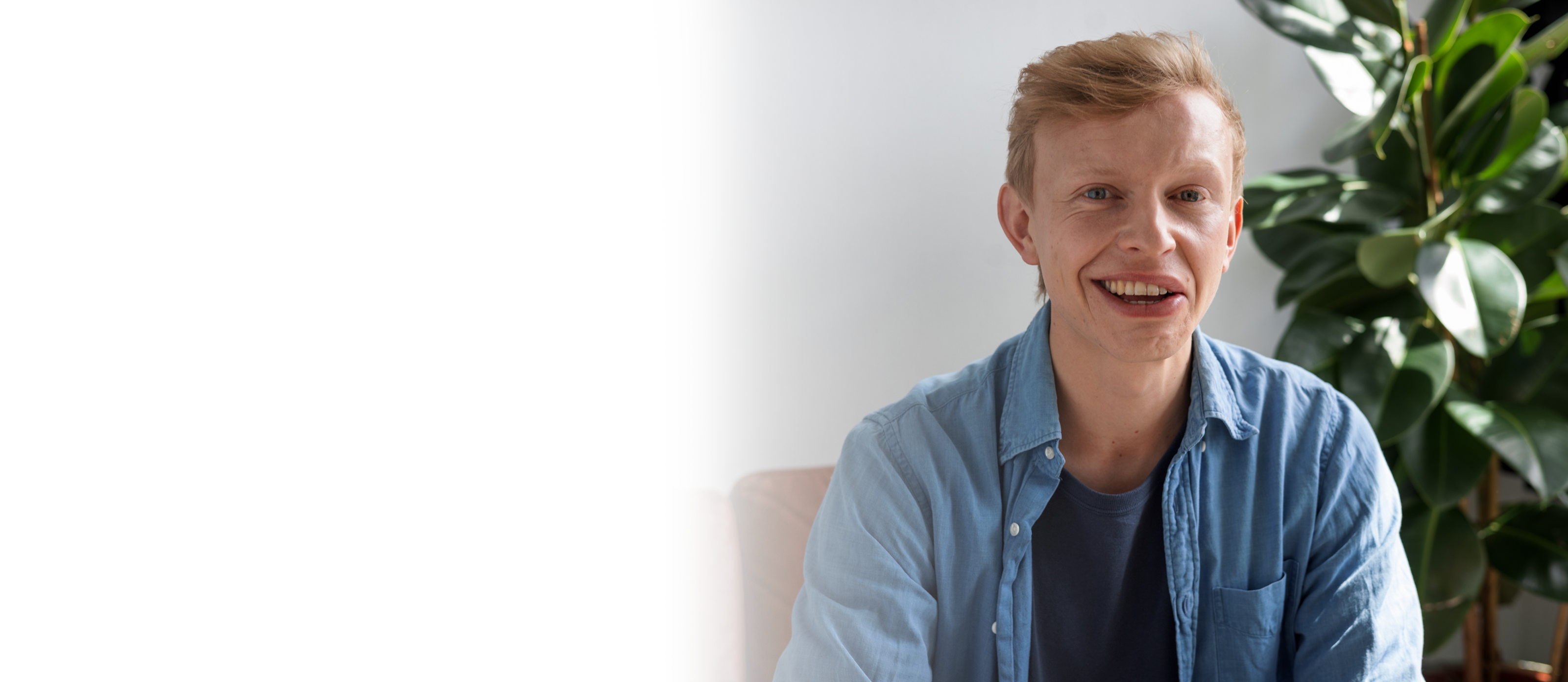 Junger Mann mit Synkinesen lächelt charmant.