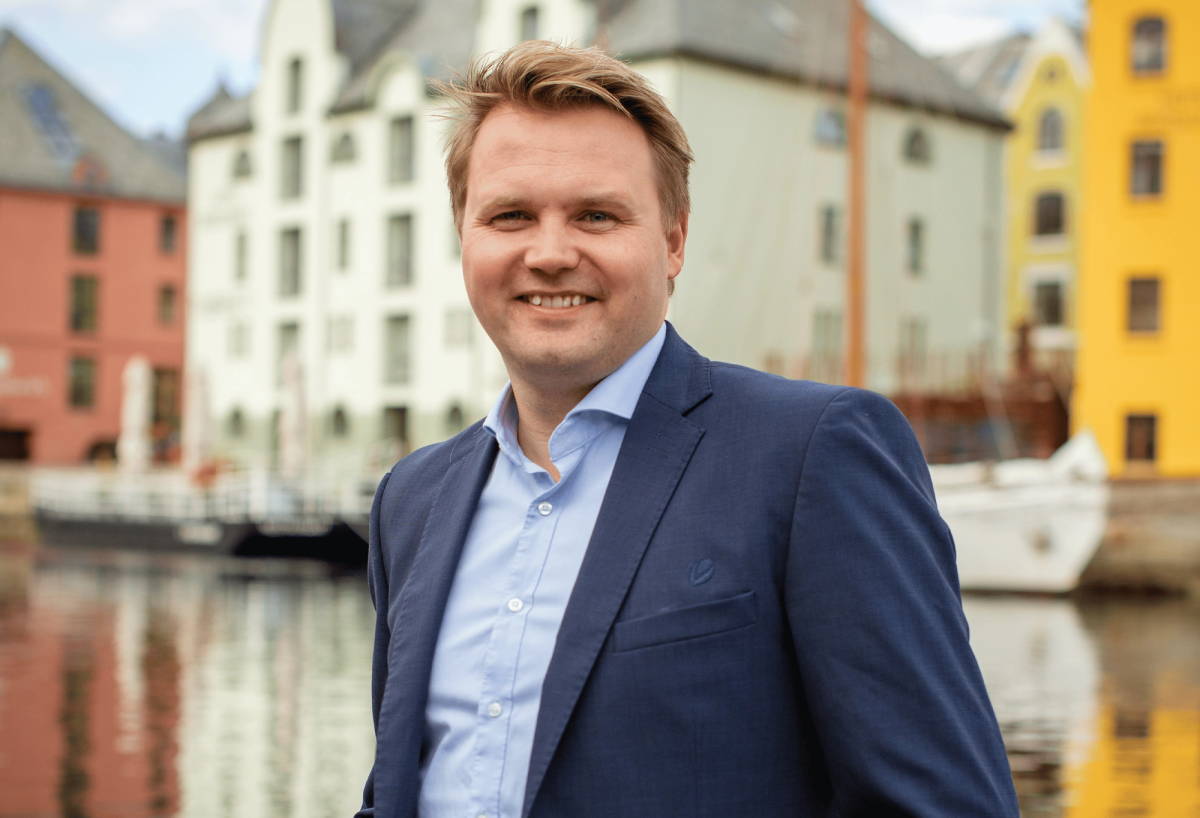 Mannlig rådgiver som står oppstilt i blå dress og lyseblå skjorte