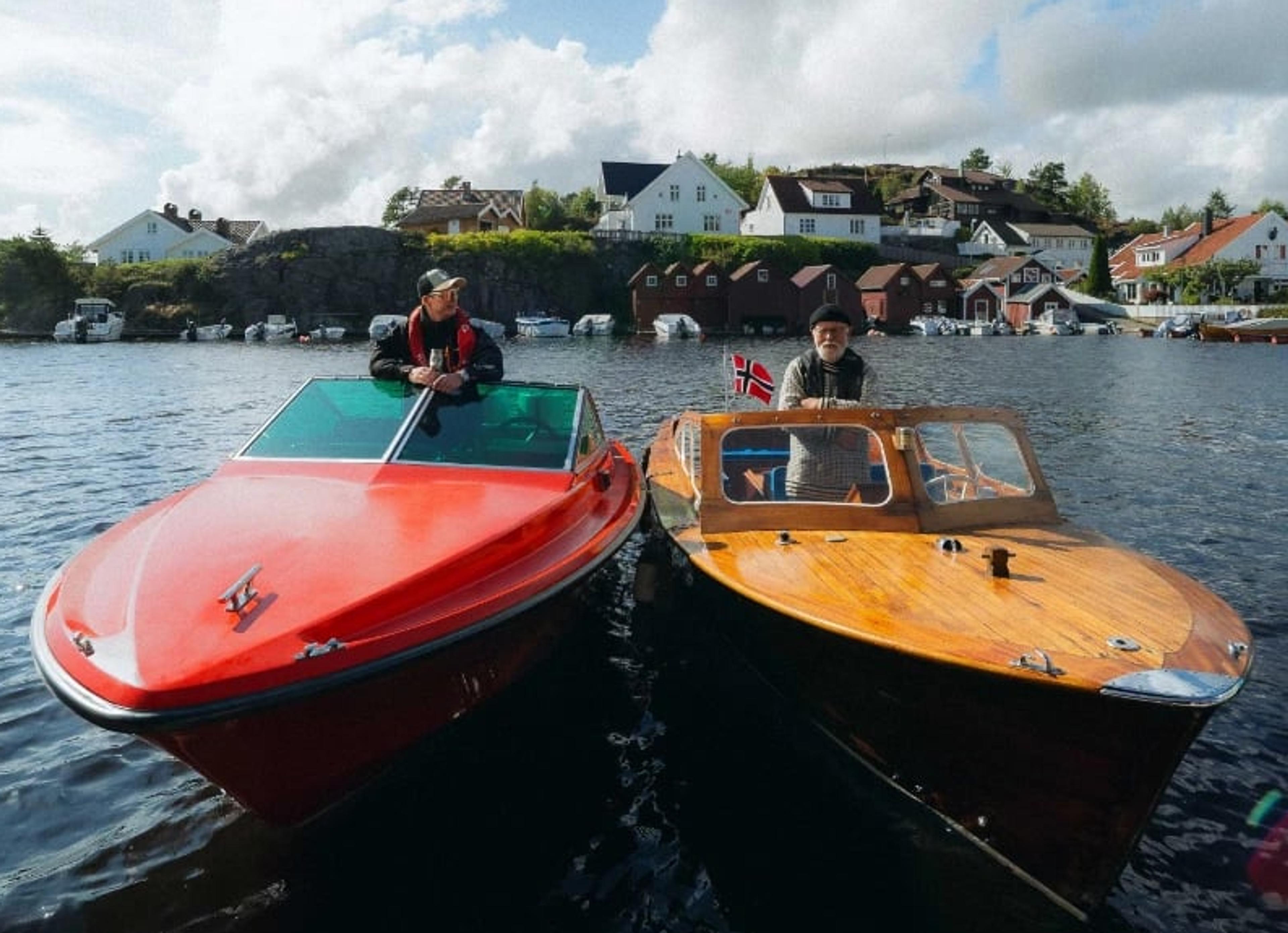 En rød og en gul båt på havet med menn i hver båt
