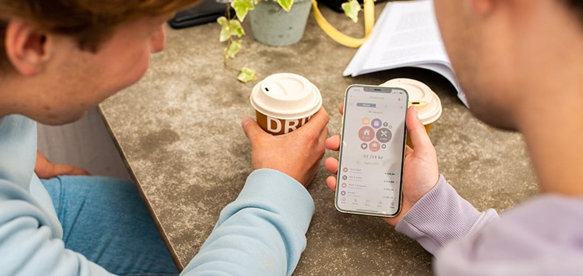 To menn ser på skjermbilde av Sparebanken Norge sin mobilbank-app