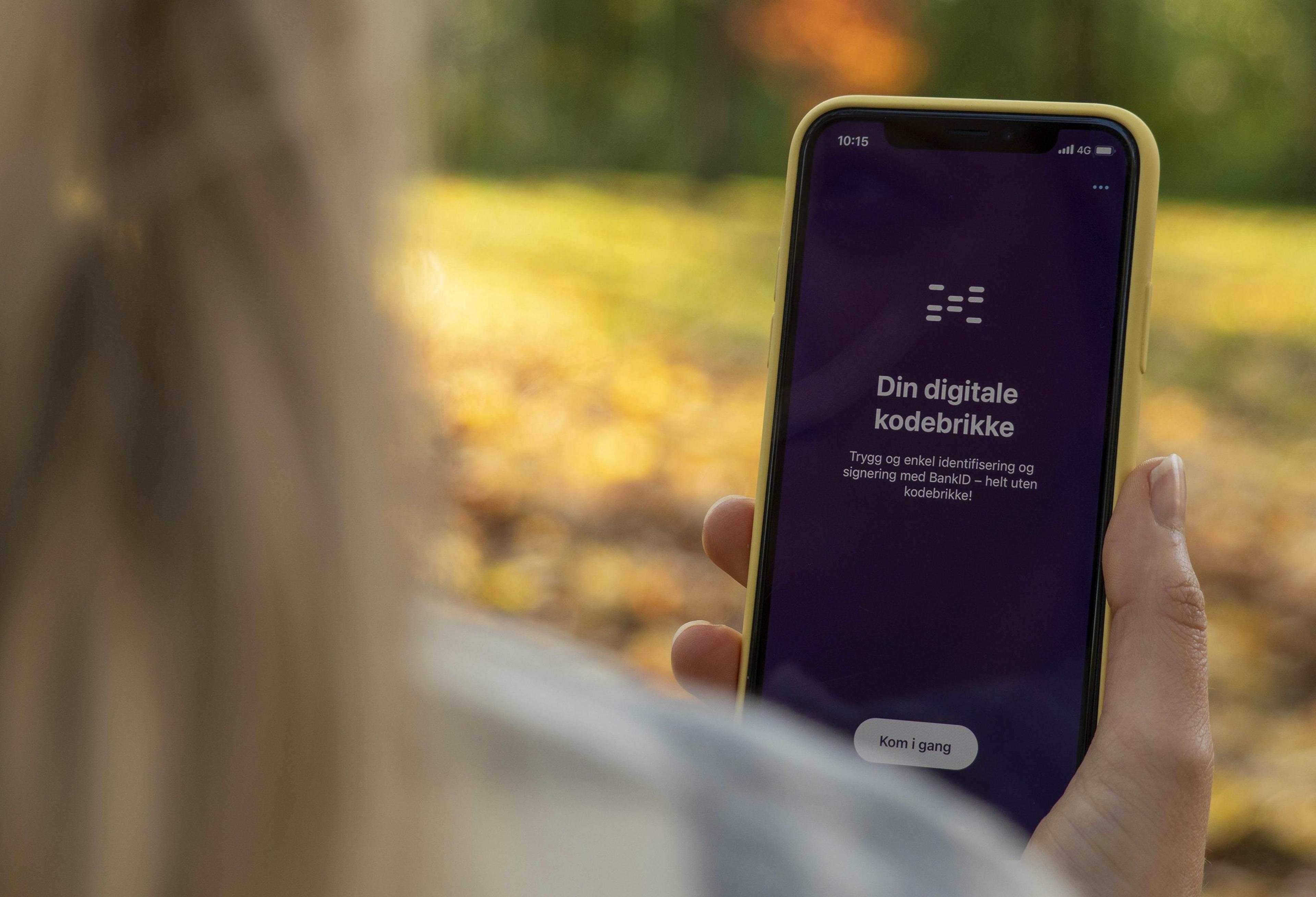 Bilde av en hånd som holder en mobil som viser bilde fra BankID-appen