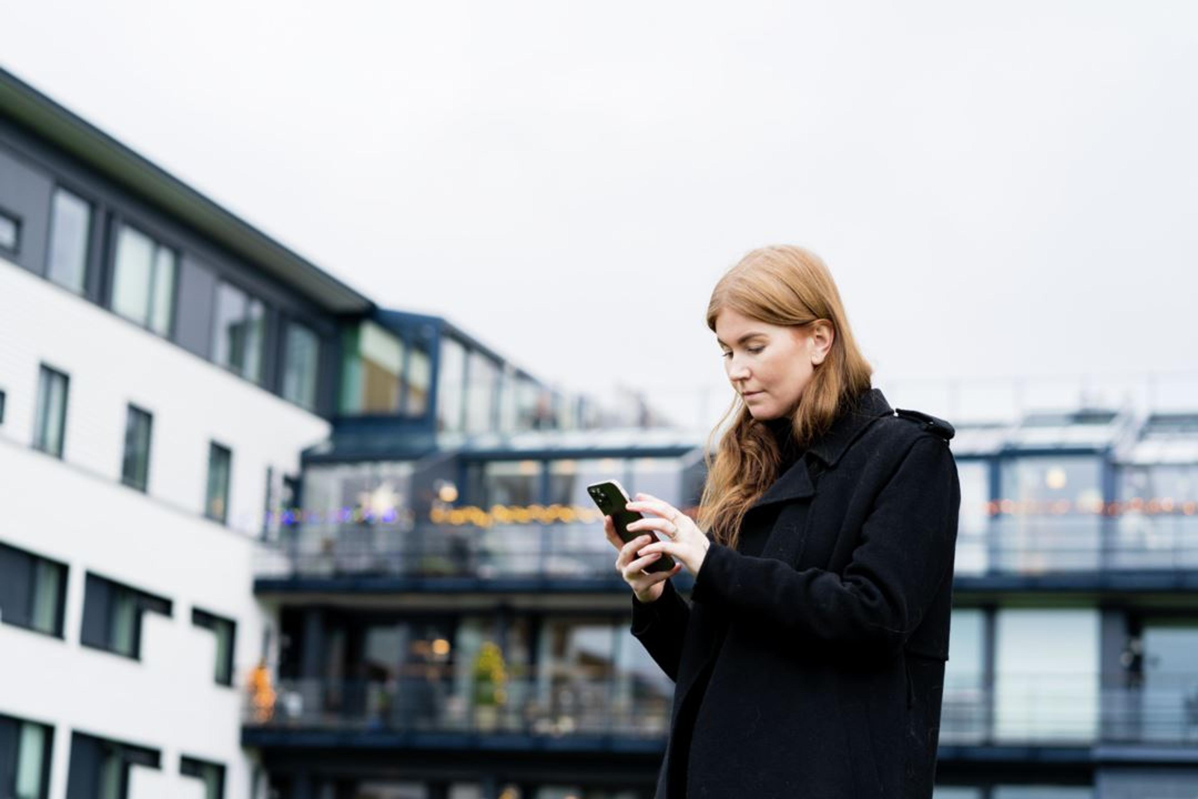 Kvinne ser på telefonen sin