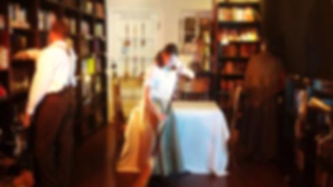 Julie sweeping the floor in front of a table, two other figures have their backs turned