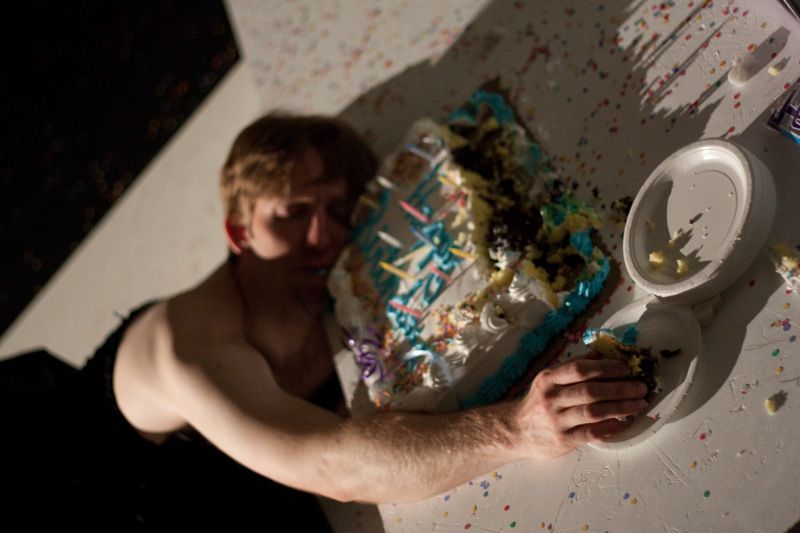 a dead body with short hair and a dress, face down in a birthday cake