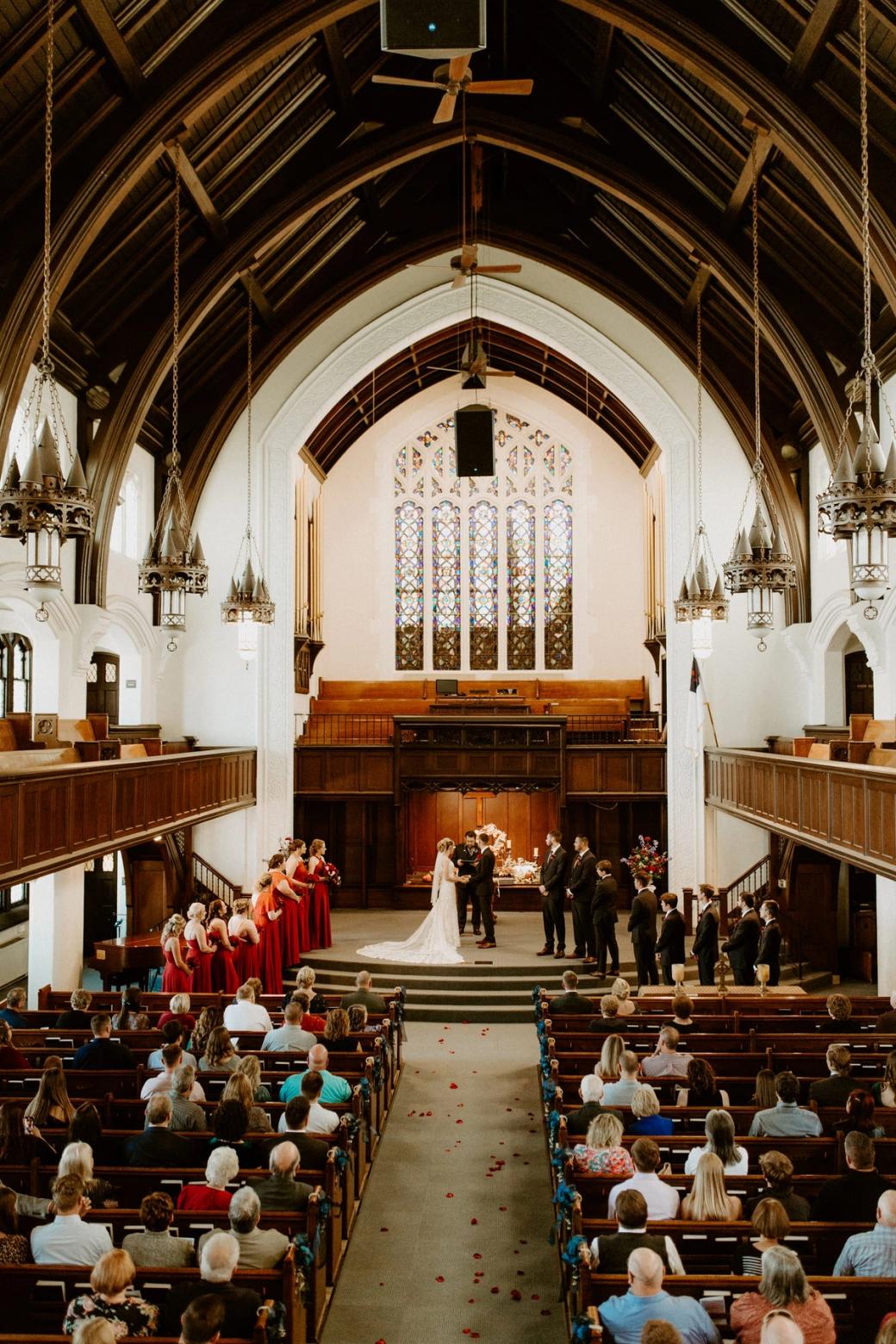 A wedding seen from the balcony, the wedding party at the chancel and the guests filling the pews below