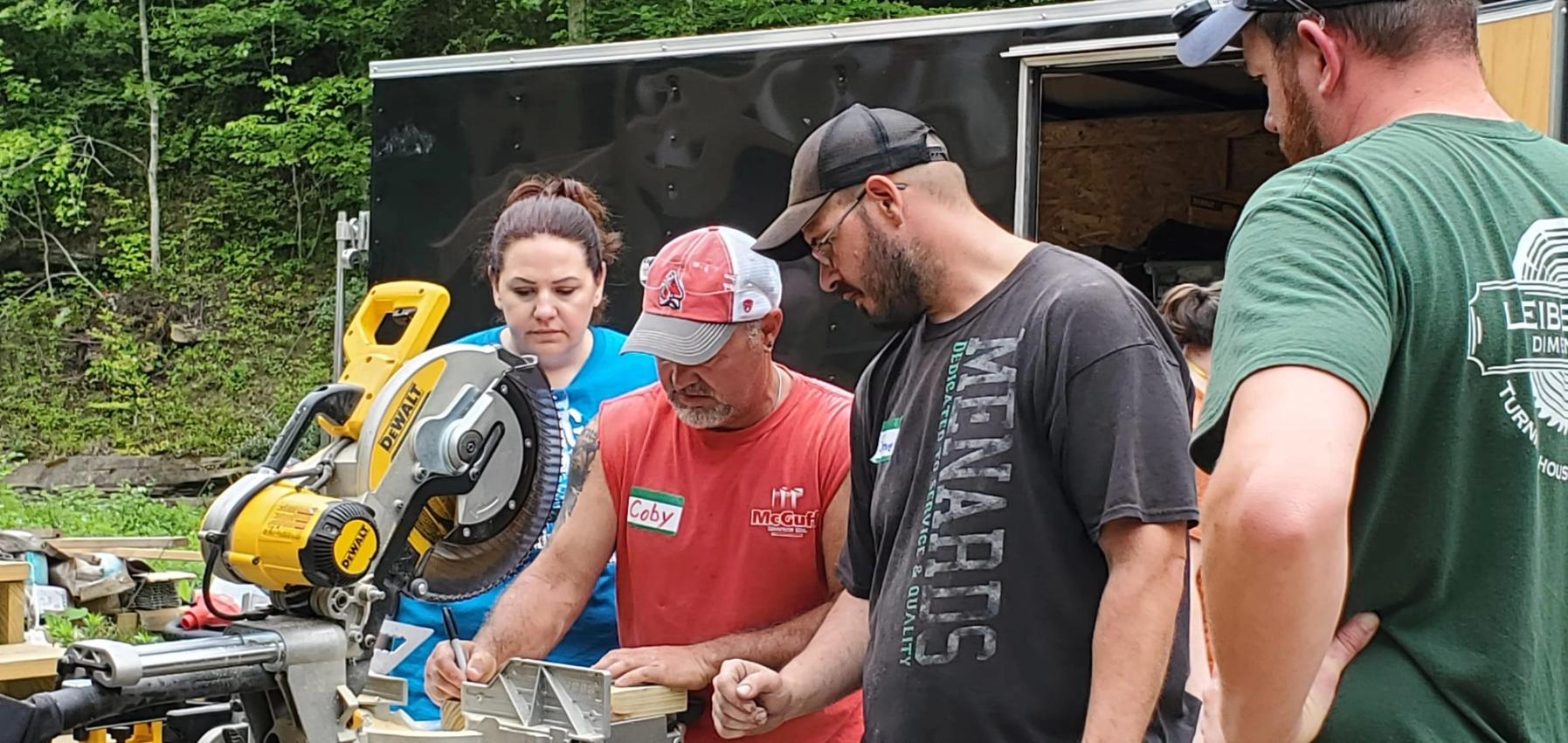 A group of volunteers working together on an outdoor building project during a mission trip.