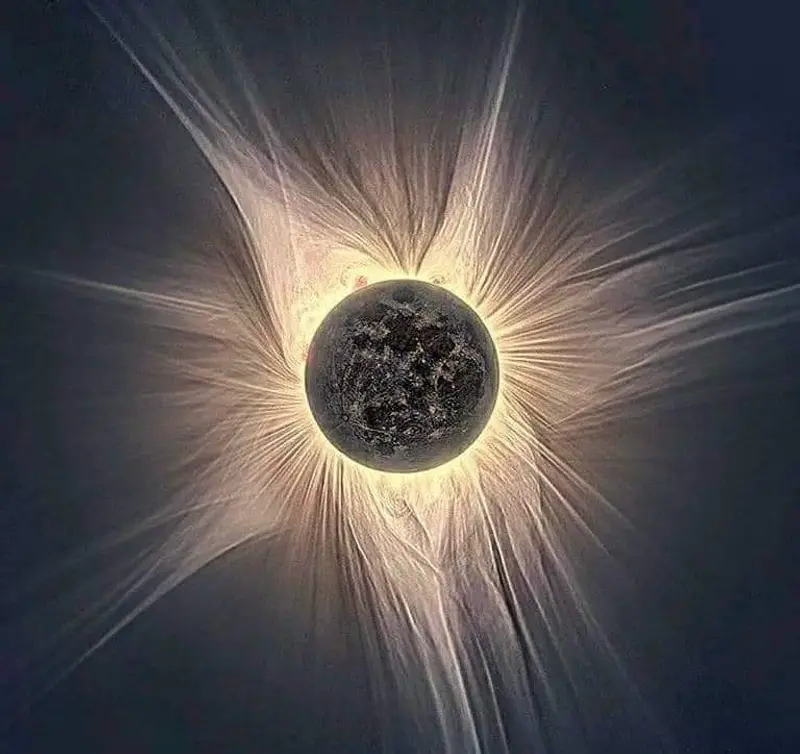 A stunning picture of the moon in front of the Sun during the April 8th, 2024, total eclipse. Rays of light can be seen in a corona shape beaming from behind the moon which has blotted out the sun.