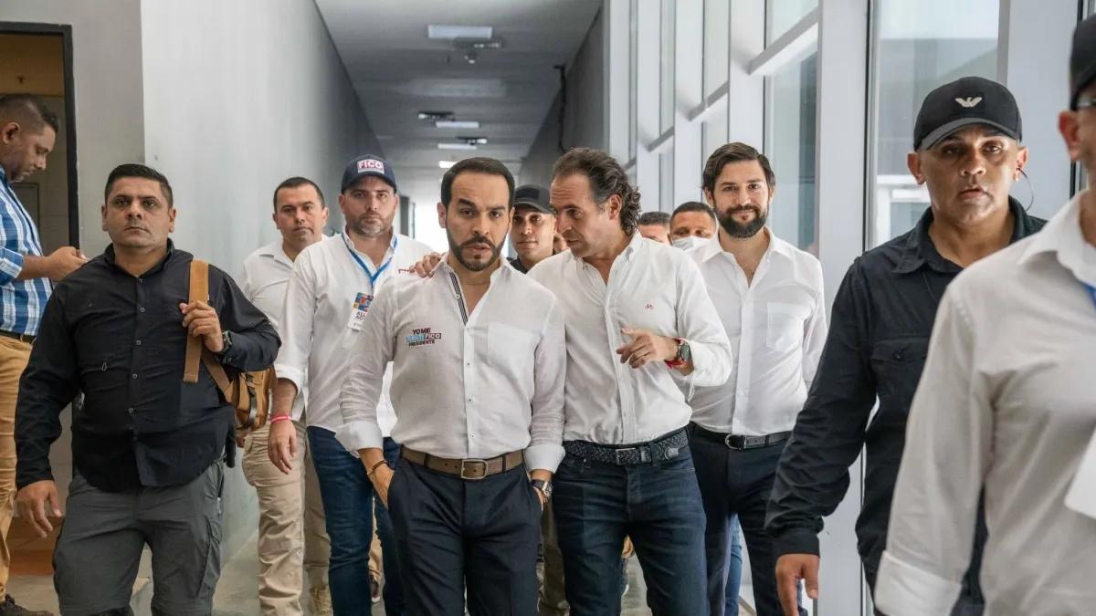 Abelardo de la Espriella y Federico Gutiérrez caminan juntos por un pasillo, rodeados de acompañantes.