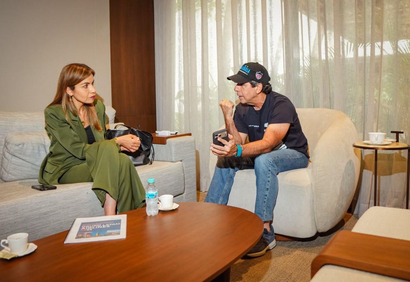 Alejandro Char conversa con una mujer durante una reunión.