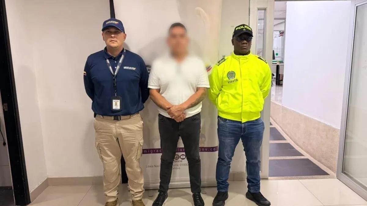 Alias El Mexicano, con el rostro difuminado, custodiado por agentes de la Policía tras su captura en Medellín.