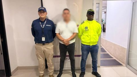 Alias El Mexicano, con el rostro difuminado, custodiado por agentes de la Policía tras su captura en Medellín.