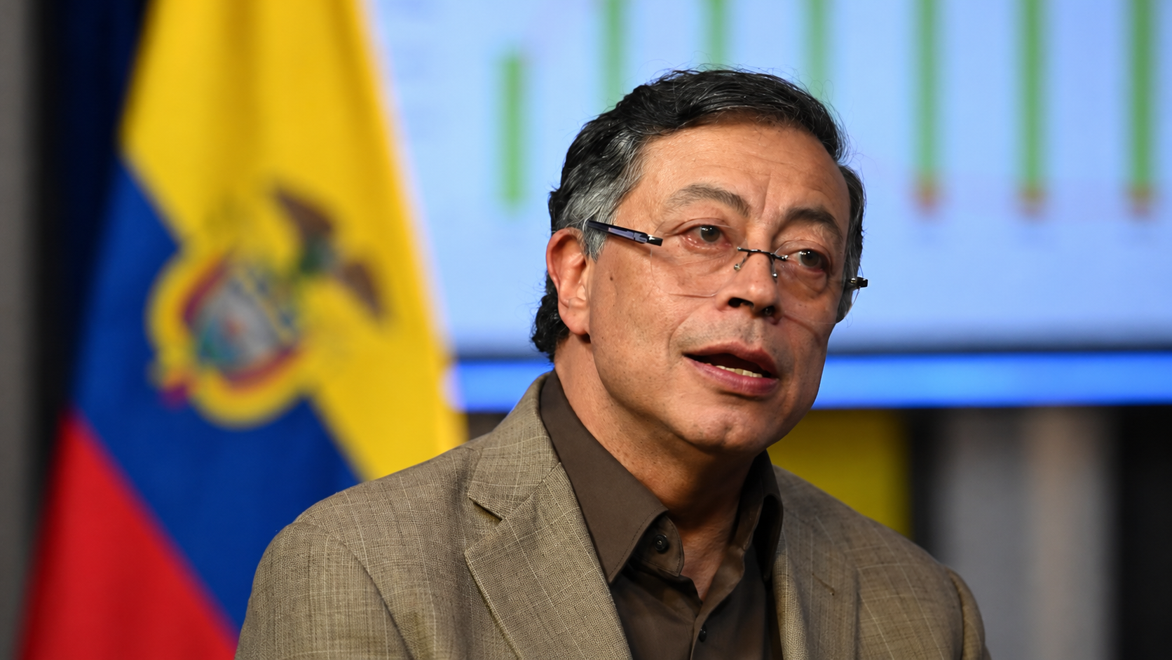 Gustavo Petro en una imagen editorial con la bandera de Colombia al fondo