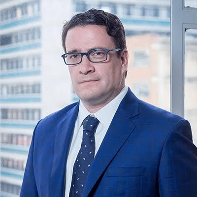 Iván Cancino, ministro de Justicia, con traje azul y gafas.