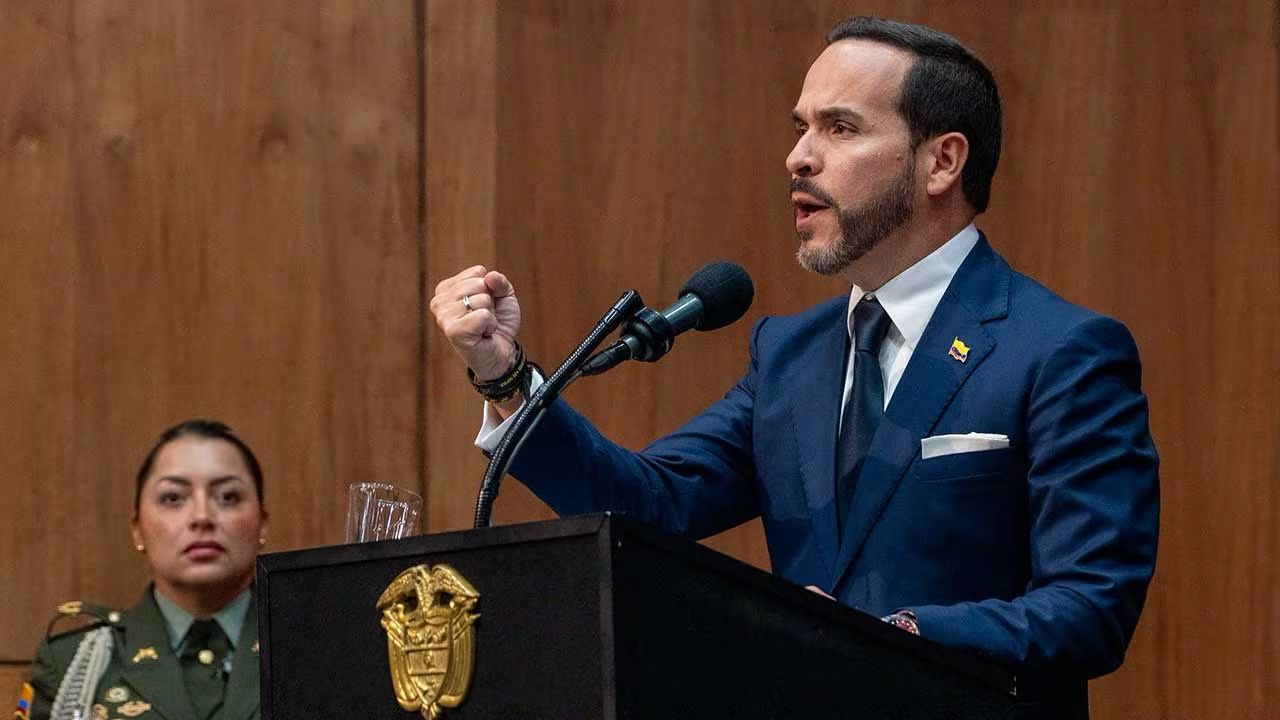 Rodrigo Lara habla ante un micrófono desde un atril, vestido con traje azul.