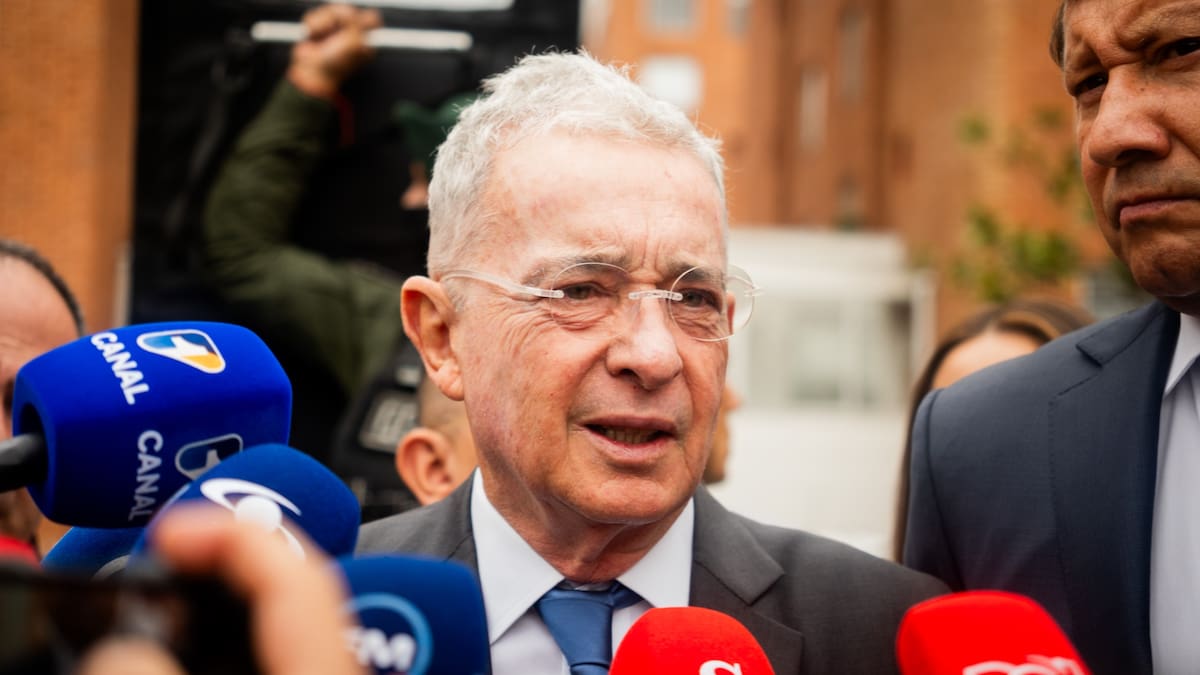 El expresidente Álvaro Uribe habla ante micrófonos de medios a las afueras del búnker de la Fiscalía en Bogotá.