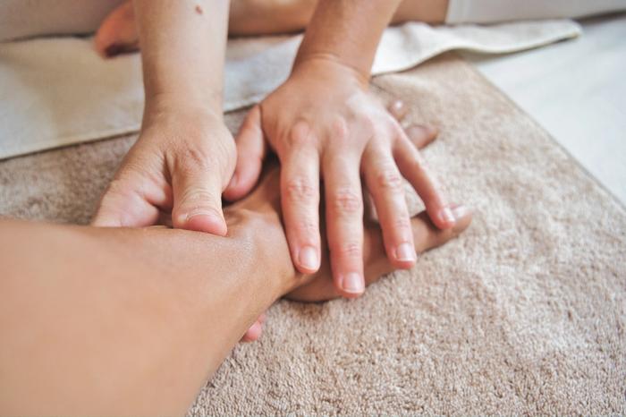 a physiotherapists hands completing physiotherapy on a wrist