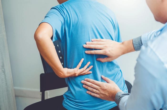 Physiotherapist consulting with patient for back problem