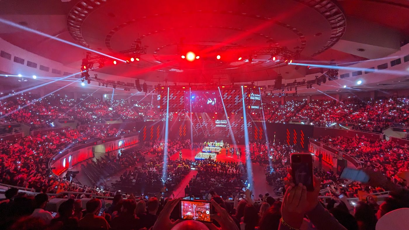 Crowded robotics competition arena illuminated in red