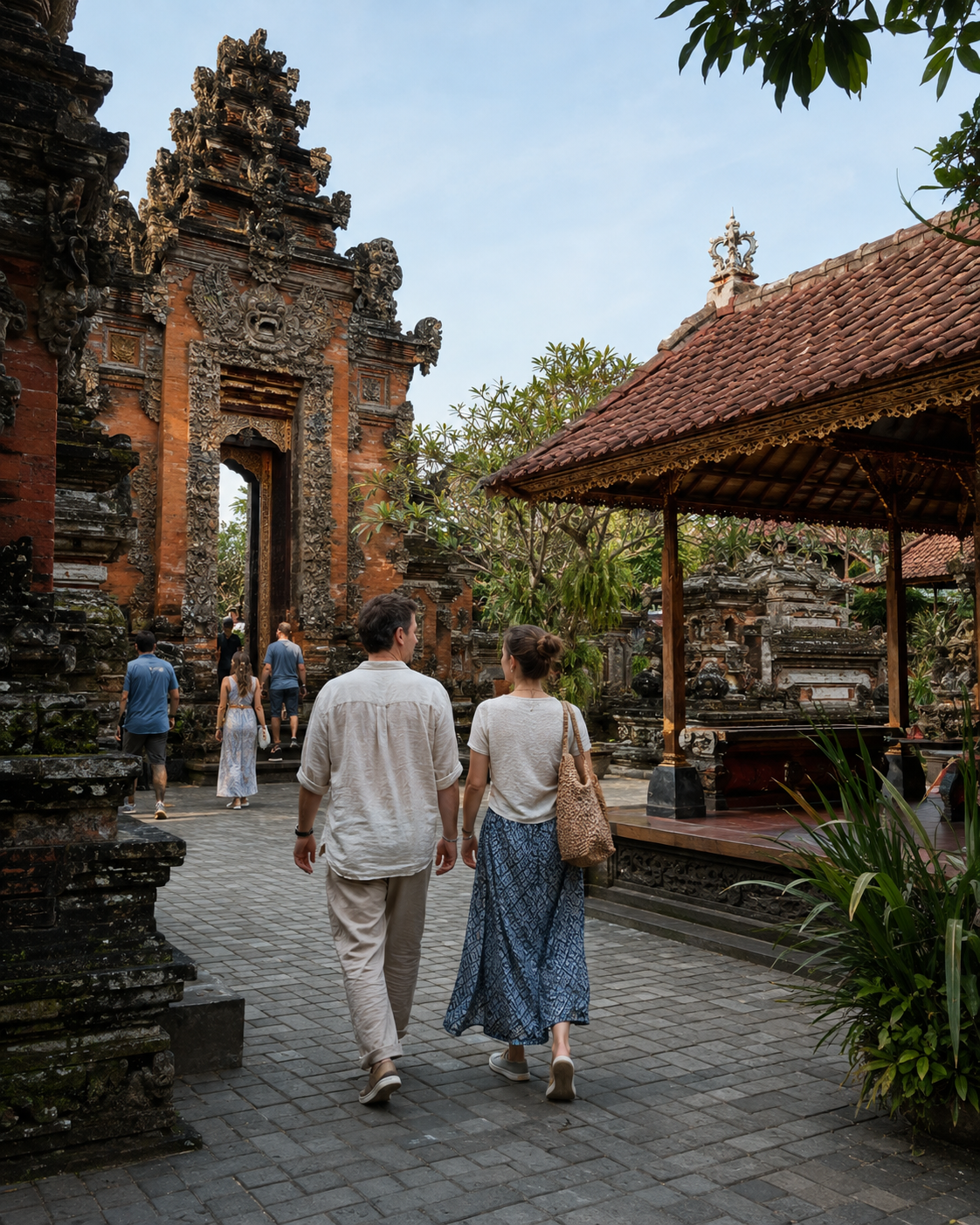 Dua wisatawan berjalan di halaman Puri Ubud dengan latar arsitektur tradisional Bali