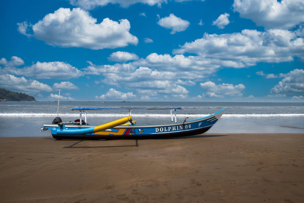 Perahu dolphin watching berada di tepi Lovina Beach, Bali Utara